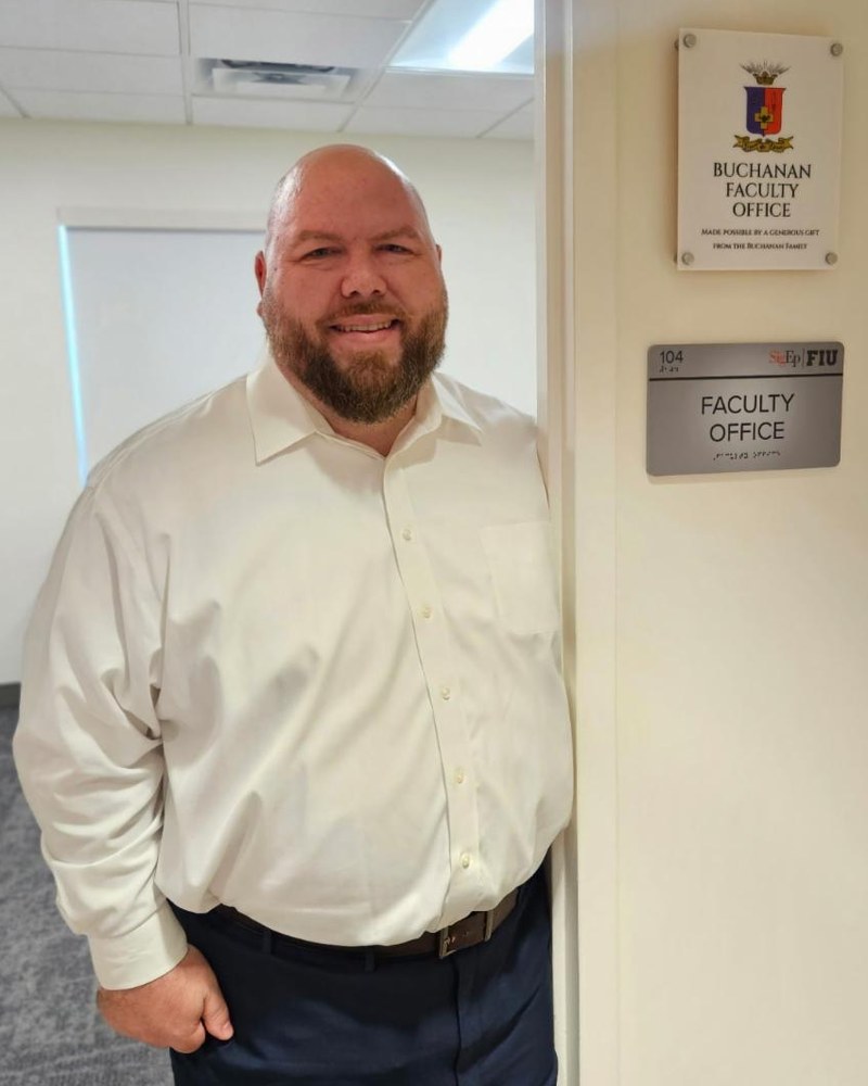 Bill Buchanan beside the Buchanan Faculty Office plaque